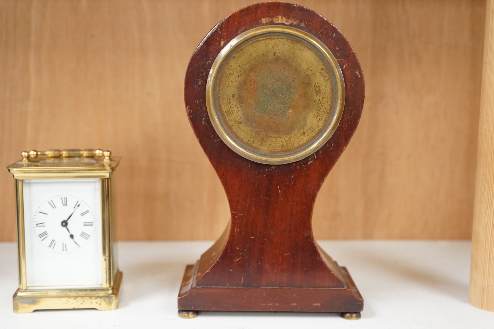 An Edwardian inlaid mahogany balloon clock and a brass cased carriage timepiece, largest 23cm high. Condition - fair, untested